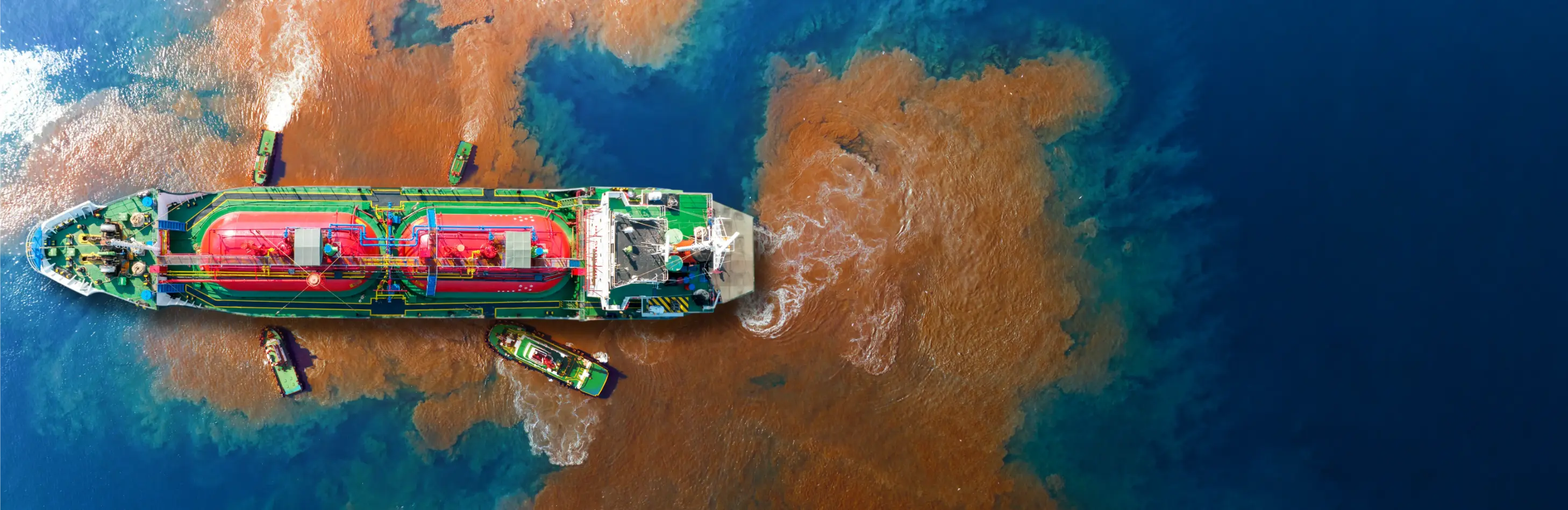 Aerial view of an LPG cargo ship navigating brown coastal or estuarine waters